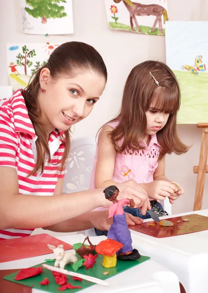 Mother and daughter playing plasticine.