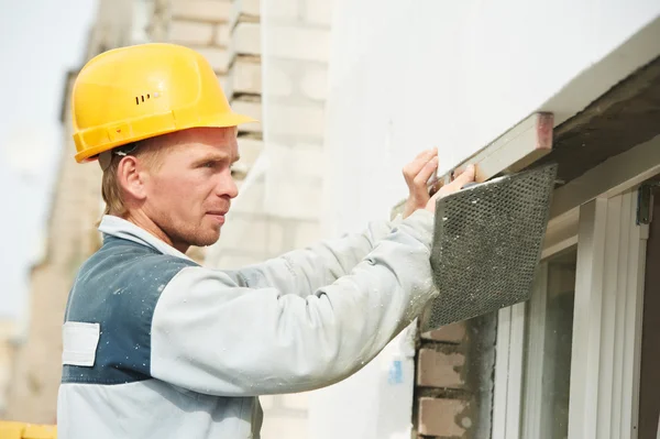 Builder facade plasterer worker with level