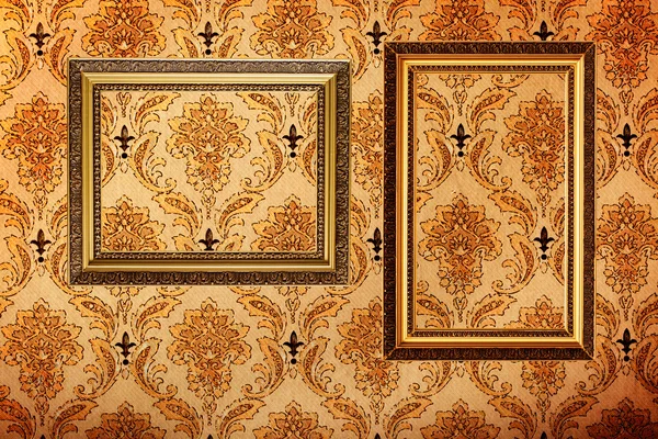 Vintage gold plated picture frames on retro wallpaper