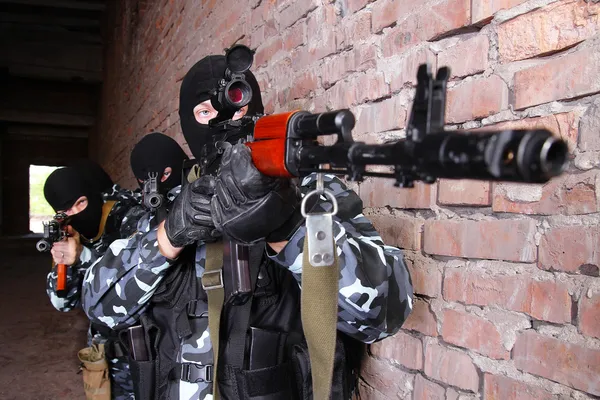 Soldiers in masks aiming the target with guns