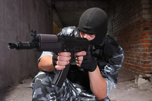 Soldier in black mask targeting with a gun
