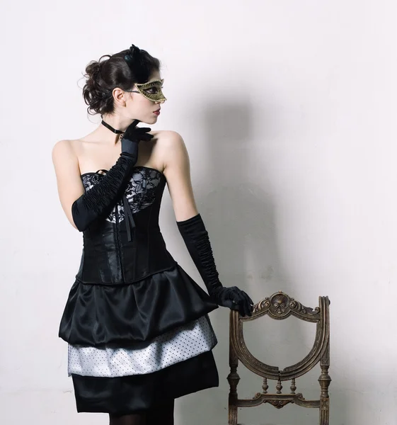 An elegant young woman in fancy dress in retro interior.