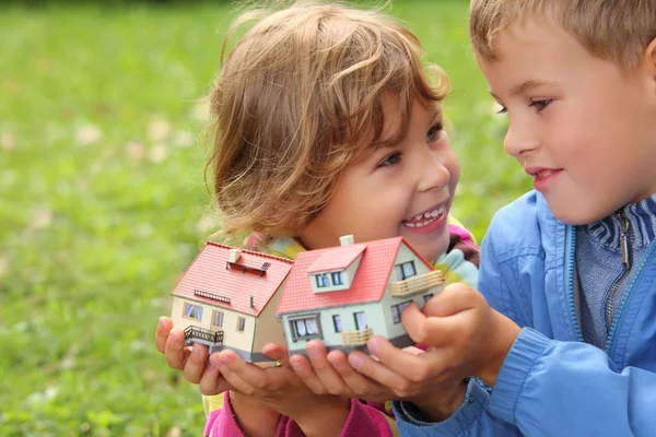 Children with toy small houses in hands outdoor