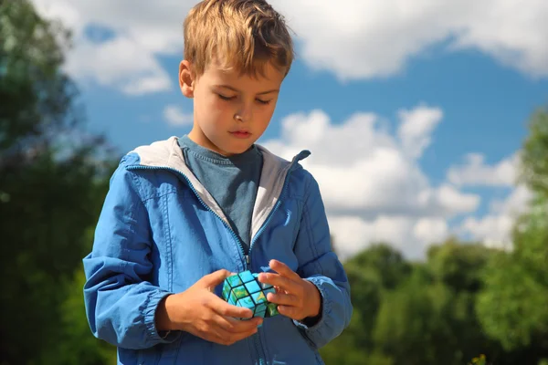 Boy with magic cube outdoor in summer