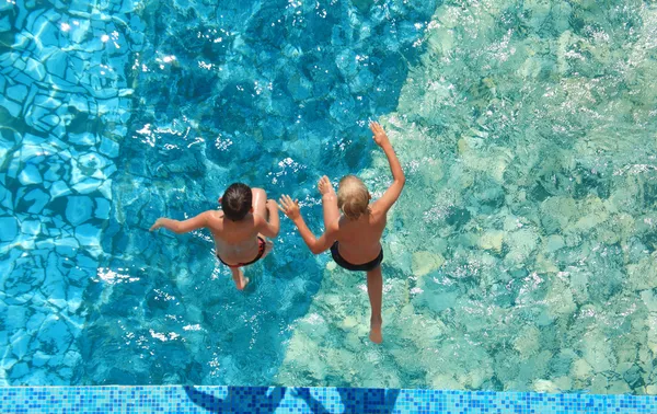 Two children jump in water, top view