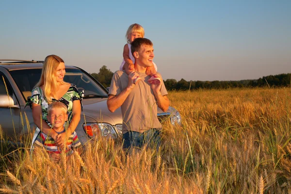 Family with offroad car on wheaten field