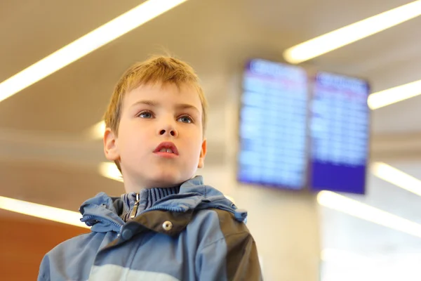 Portrait of little boy in airport looking into the distance blue