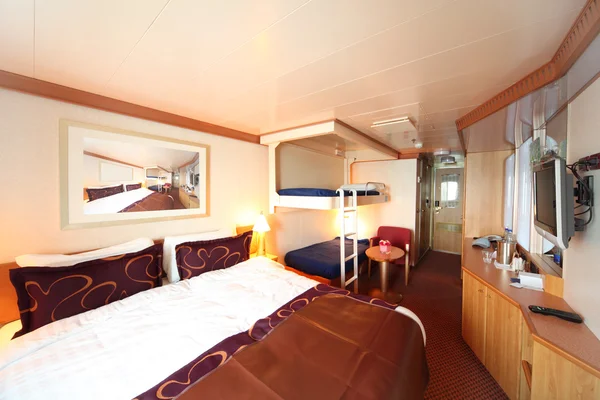 Ship cabin with big double bed and two children beds general vie