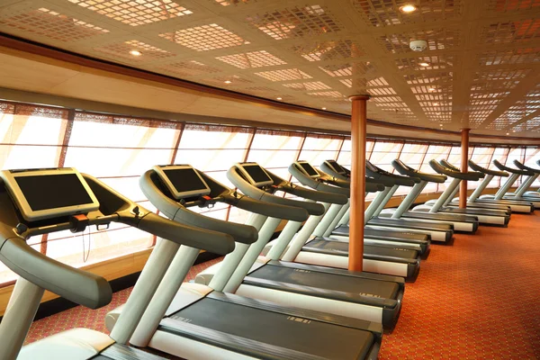 Large gym hall with treadmills near windows in cruise ship gene