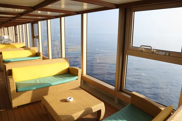 Room for rest with sofas and tables near window in cruise liner