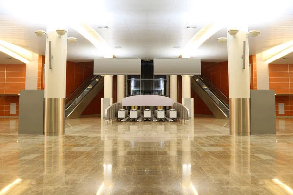 Big modern hall with granite floor, columns and two escalators i