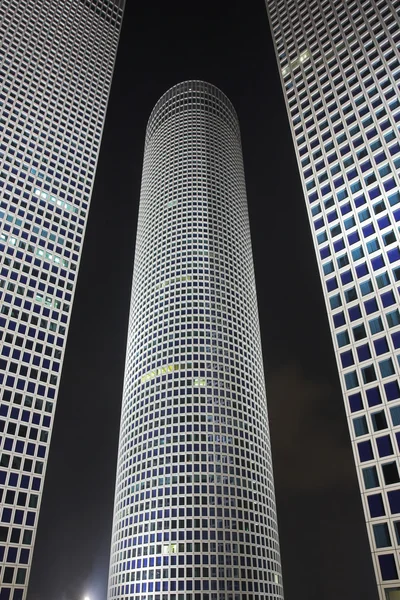 Round, square and triangular skyscrapers at night