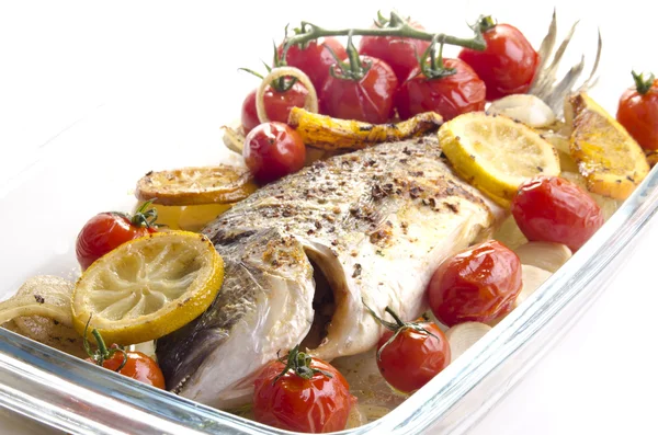 Baked sea bream with tomato, garlic and lemon slices