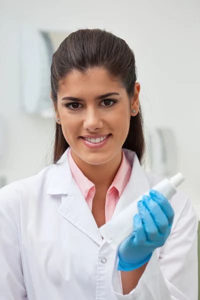 Female dentist holding toothpaste
