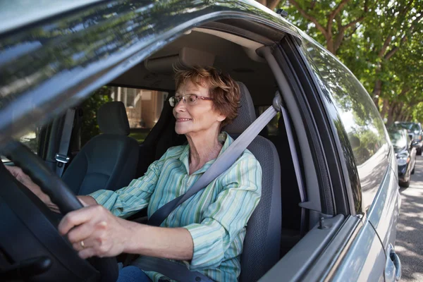 Smiling senior woman driving car