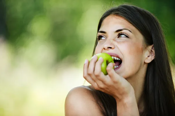 Portrait young charming woman biting apple