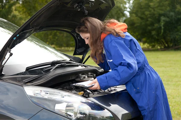 Female car mechanic with in action