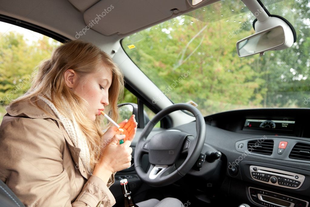 Smoking woman driving a car — Stock Photo © photomak 7361375