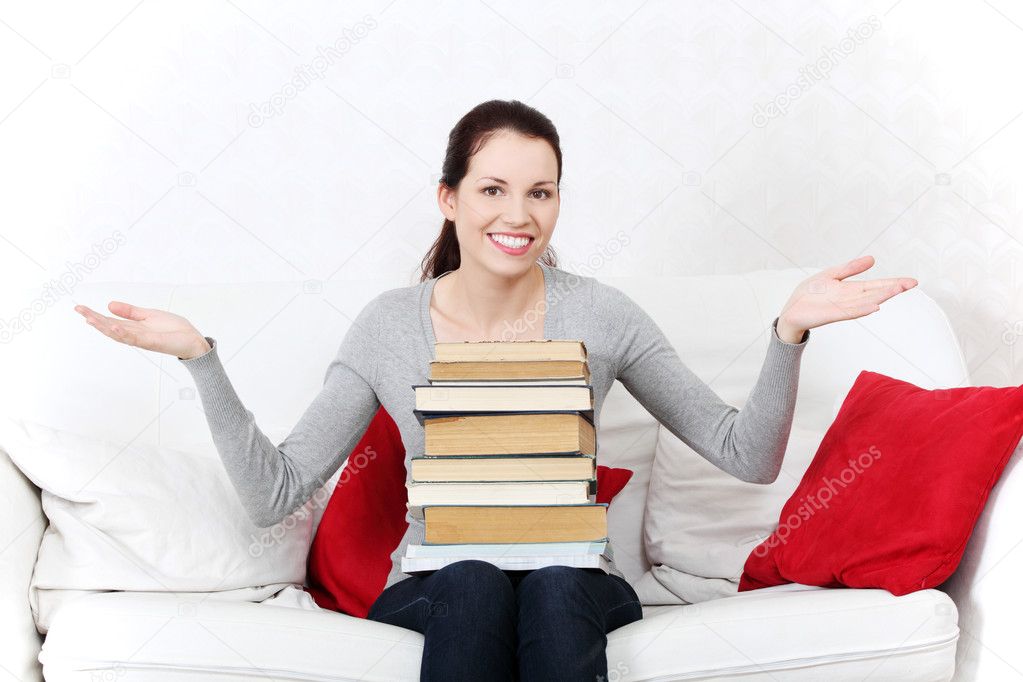 Free Stock Photo: Smiling female student holding a pile of books.