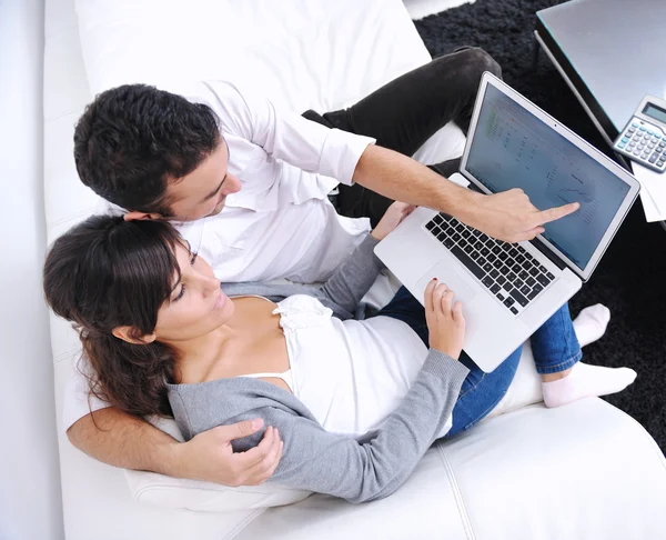 Joyful couple relax and work on laptop computer at modern home