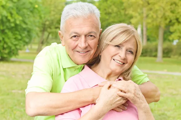 Happy elderly man embracing mature woman