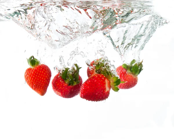 Strawberries dropped into water splash