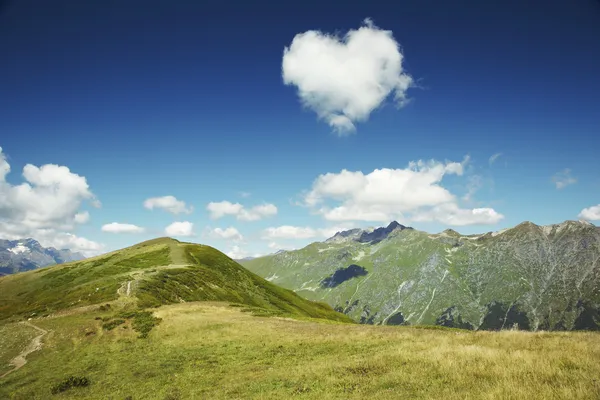 Caucasus mountains.Heart from cloud in the blue sky