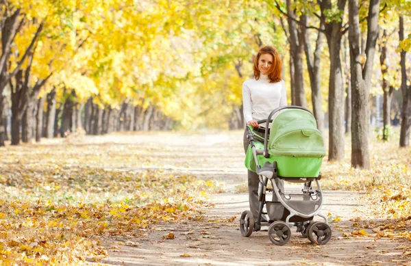 Happy young mother with baby in buggy