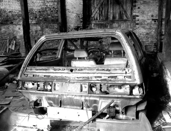 Car wreck in barn wreck, black and white