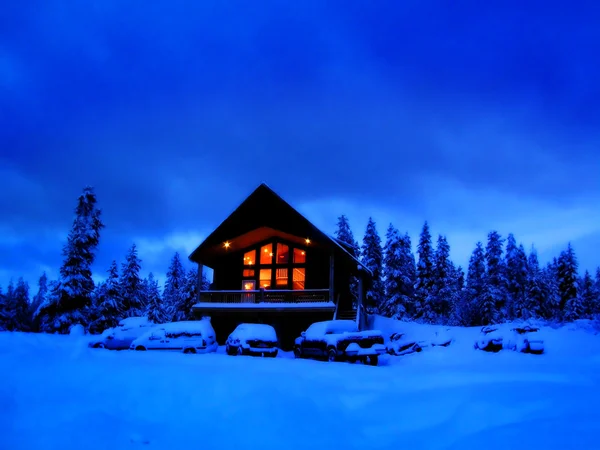 Winter Cabin at night with glowing warm windows