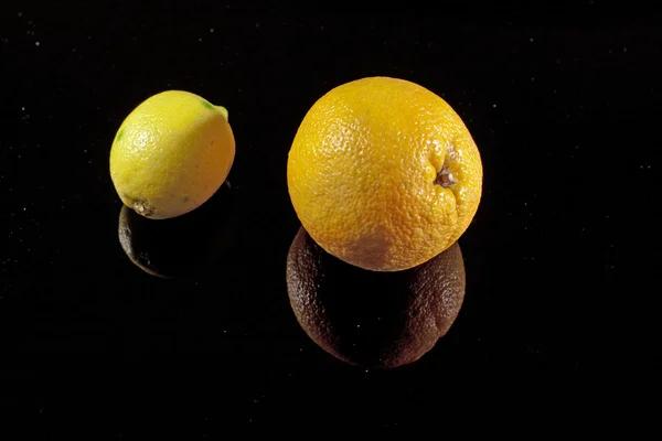 Lemon and orange on the black mirror