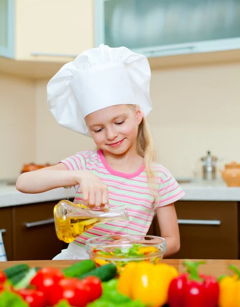 Little girl with oil preparing healthy food on kitchen
