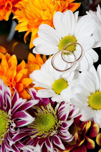 Wedding gold rings lie on a bunch of flowers for the bride by Aleksey 