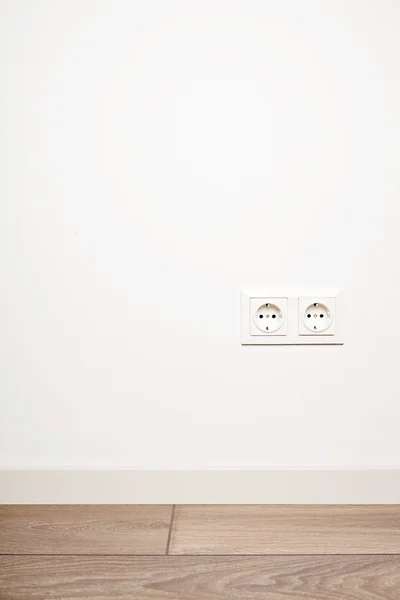 Double electricity power socket on blank white wall