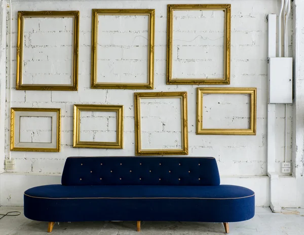 Long blue fabric sofa and gold picture frame