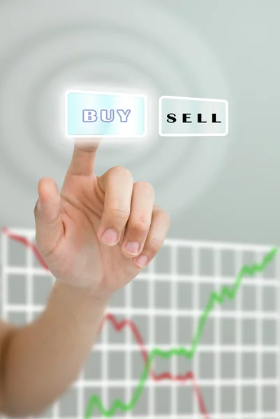 Hand pushing buy button with stock market graph