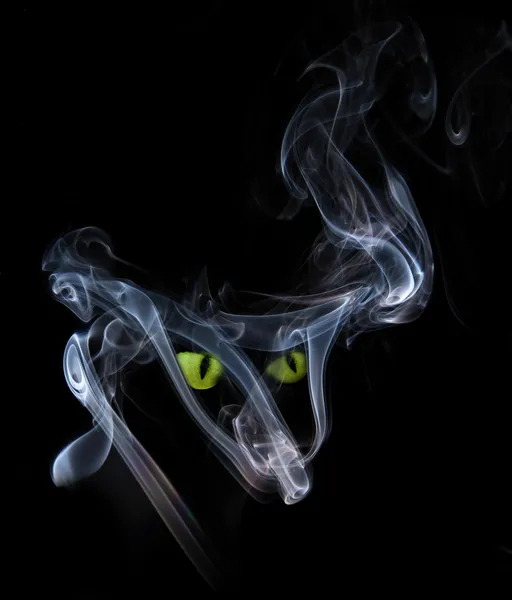 Green cat eyes in a smoke