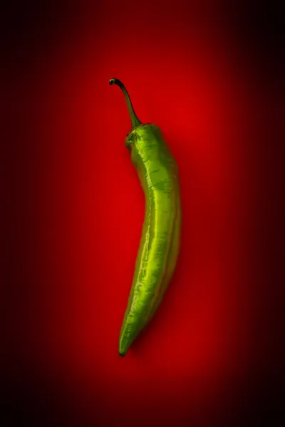 Hot green pepper on a red background
