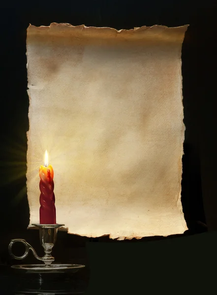 Vintage paper scroll lit a candle