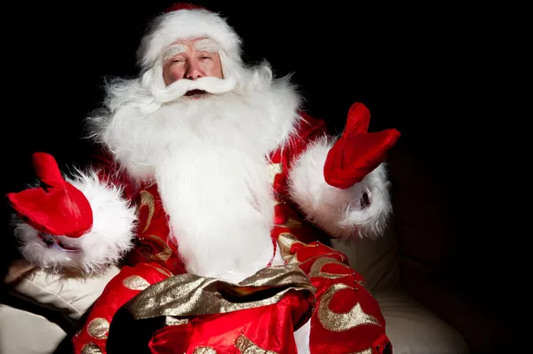 Santa sitting with a sack indoor at dark night room