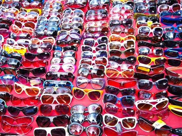 Plastic sunglasses on red table