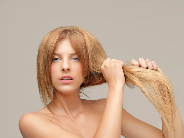 Woman pulling dry hair split ends