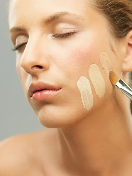 Woman trying shades of foundation on jaw
