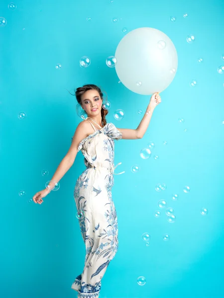 Happy woman with balloons on blue background