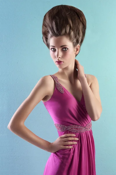 Young woman in elegant pink dress and elegant up-do