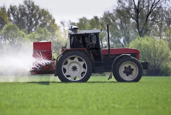 Tractor spraying a filed with pesticides/fertilizers