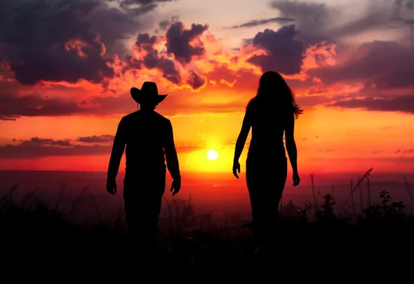 Cowboy couple silhouette at sunset