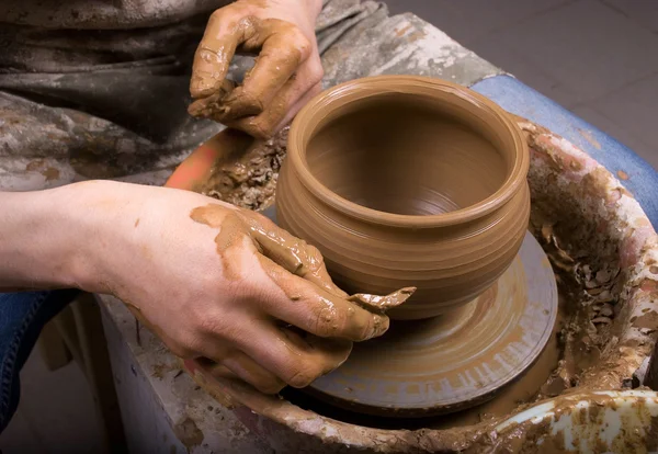 Hands of a potter, creating an earthen jar on the circle — Stock Photo #7902544