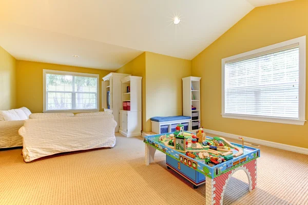 Yellow kids play room with white sofs and beige carpet