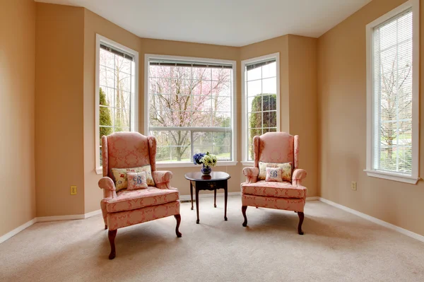 Classic living room window with two pink chairs.
